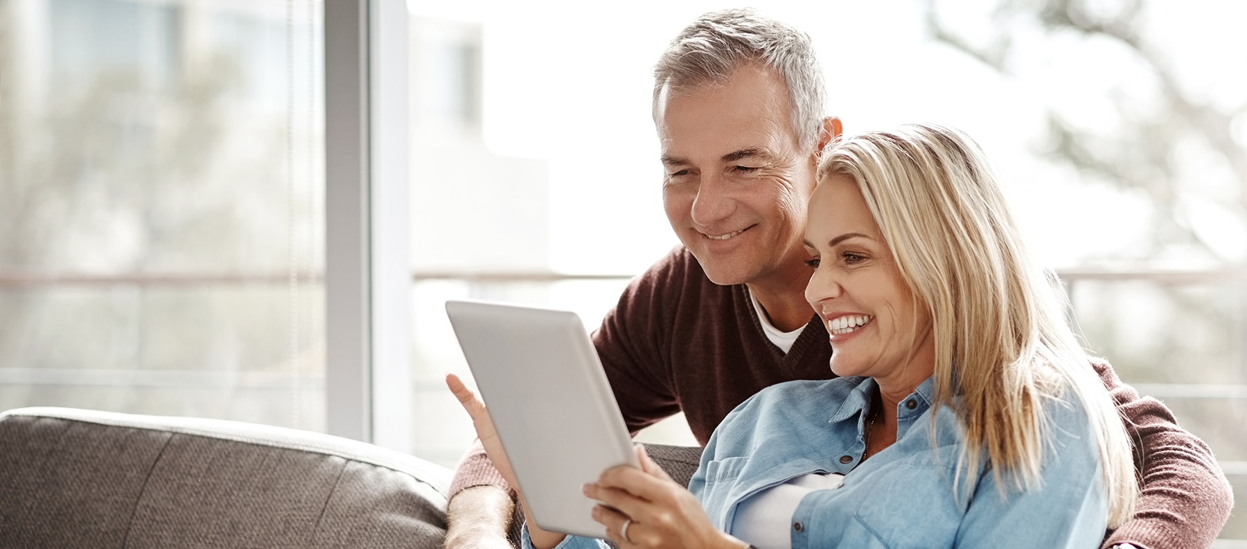 A well-lit reception area with a desk, computer monitor, and potted plant.
